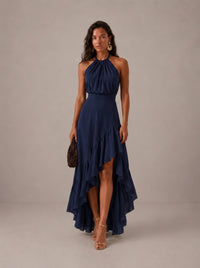 Elegante vestido de invitada de boda azul con cuello halter y bajo asimétrico de volantes