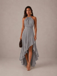 Elegante vestido de invitada de boda gris con cuello halter y bajo asimétrico de volantes