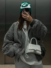 Refinada chaqueta acolchada tipo bomber gris con botones y bolsillos de solapa
