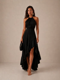 Elegante vestido de invitada de boda con negro cuello halter y bajo asimétrico de volantes